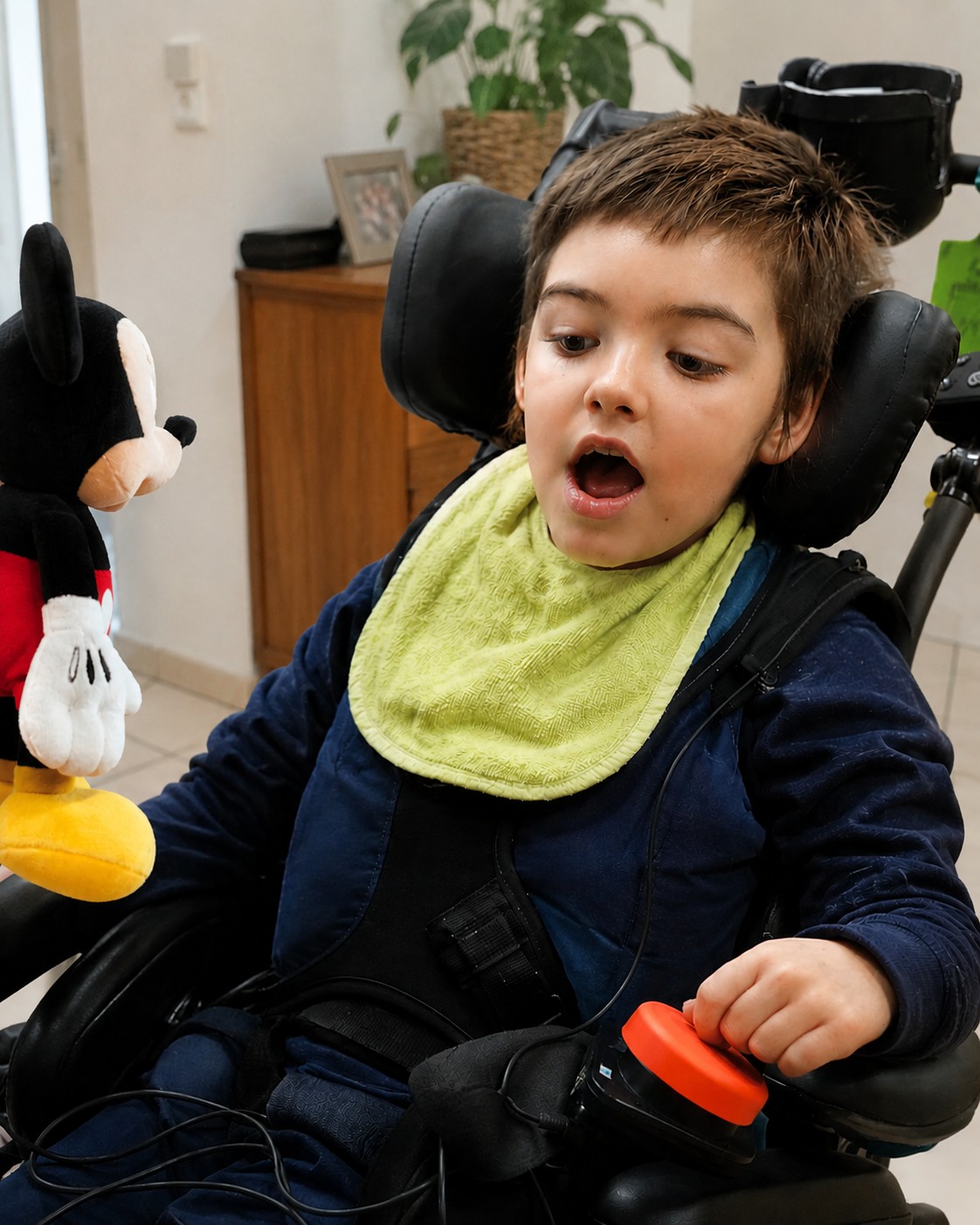 Enfant en situation de handicap moteur utilisant un contacteur pour jouer avec un jouet adapté